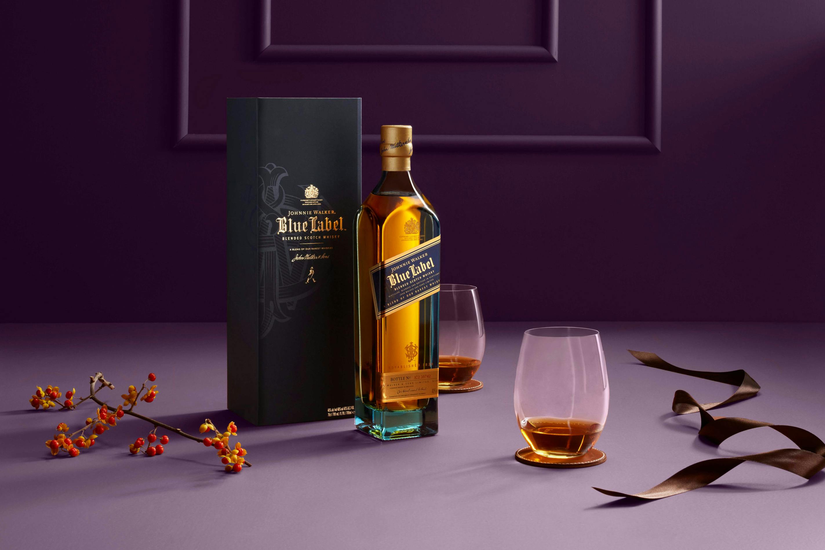 Johnnie Walker Blue on a purple background with 2 glasses and christmas decorations